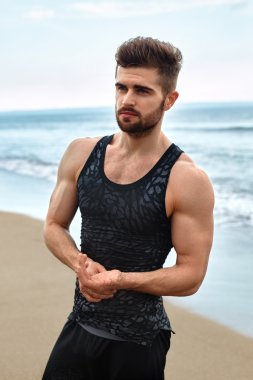 Sahilde spor giyim uygun kas vücut yakışıklı adam.