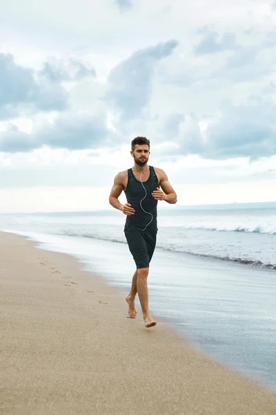 Чоловік бігає на пляжі, біжить під час тренування на відкритому повітрі. Спортивна концепція — стокове фото