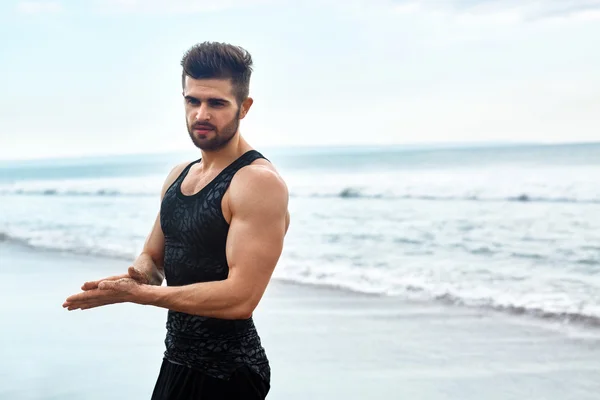 Hombre guapo con ajuste cuerpo muscular en ropa deportiva en la playa . — Foto de Stock
