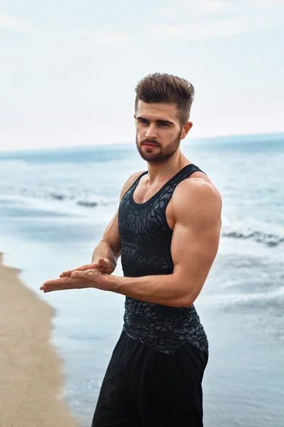 Όμορφος άντρας με κατάλληλο μυϊκή σώμα στα αθλητικά ρούχα στην παραλία. — Φωτογραφία Αρχείου
