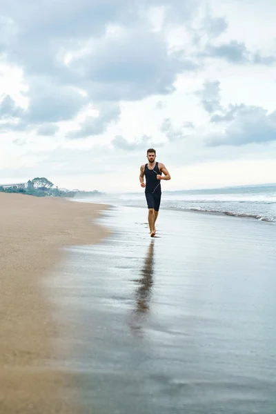 Hombre corriendo en la playa, trotando durante el entrenamiento al aire libre. Deportes —  Fotos de Stock