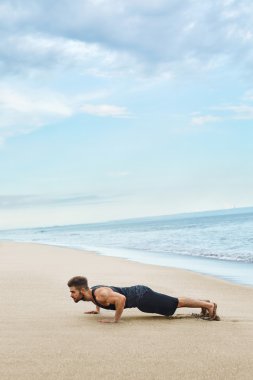 Sahilde egzersiz yukarı itin yapan erkek. Vücut egzersiz kavramı