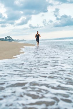Kumsalda koşan fitness adam. Runner açık egzersiz sırasında koşu