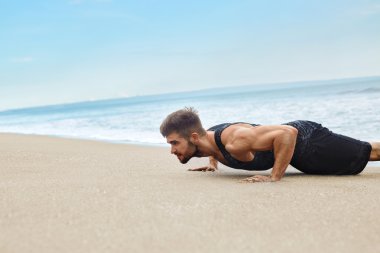 Egzersiz, sahilde egzersizleri yukarı itin yapıyor adam. Fitness Egzersiz