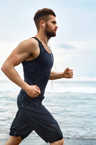 Running man jogging in spiaggia durante l'allenamento di fitness all'aperto. Sport — Foto Stock