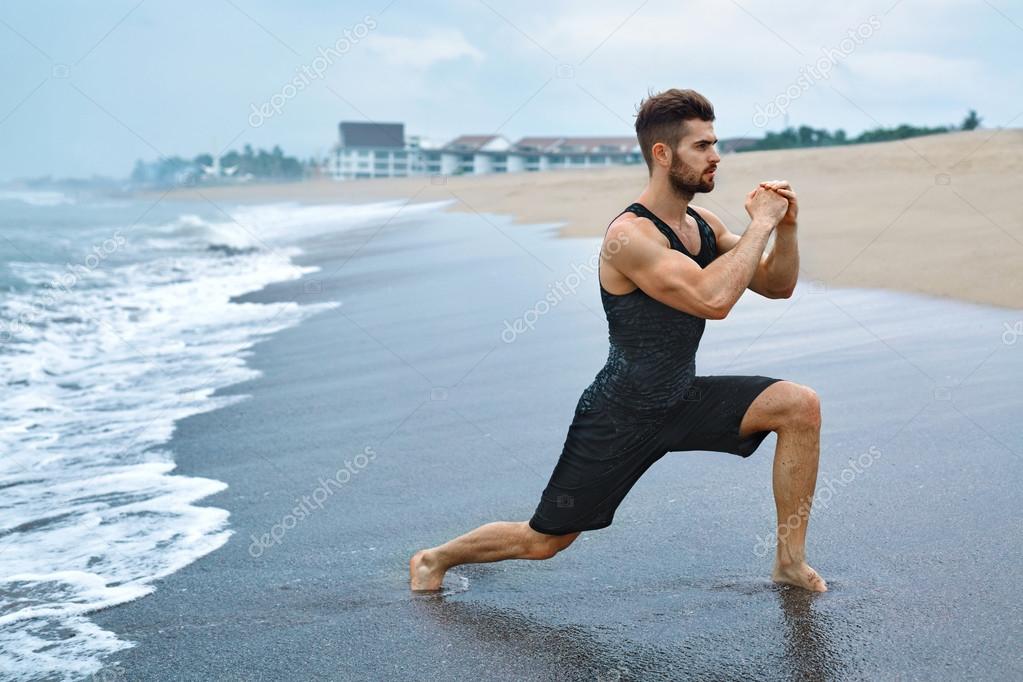 Man Doing Stretching Workout Exercises, Exercising At Beach. Fitness