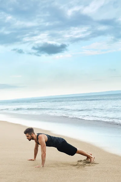 Hombre haciendo ejercicio de empuje en la playa. Concepto de ejercicio corporal — Foto de Stock