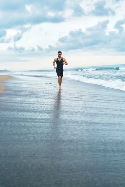 Kumsalda koşan fitness adam. Runner açık egzersiz sırasında koşu