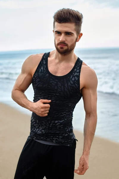 Bonito homem com ajuste corpo muscular em Sportswear na praia . — Fotografia de Stock