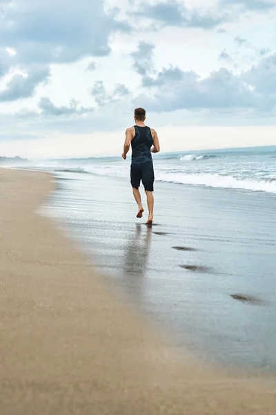 Homem de Fitness a correr na praia. Corredor Jogging durante o treino ao ar livre — Fotografia de Stock