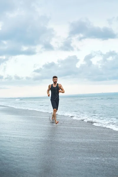 Hombre corriendo en la playa, trotando durante el entrenamiento al aire libre. Deportes —  Fotos de Stock