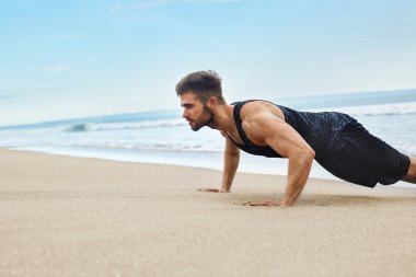 Egzersiz, sahilde egzersizleri yukarı itin yapıyor adam. Fitness Egzersiz