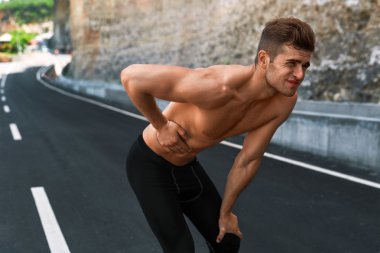 Adam açık havada çalıştırdıktan sonra mide ağrısı acı. Spor yaralanma