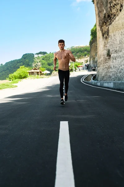 Hombre musculoso guapo corriendo y haciendo ejercicio al aire libre. Deporte, Fitness — Foto de Stock