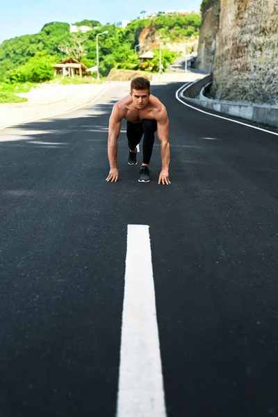 Hombre atlético listo para empezar a correr al aire libre. Concepto de entrenamiento deportivo — Foto de Stock