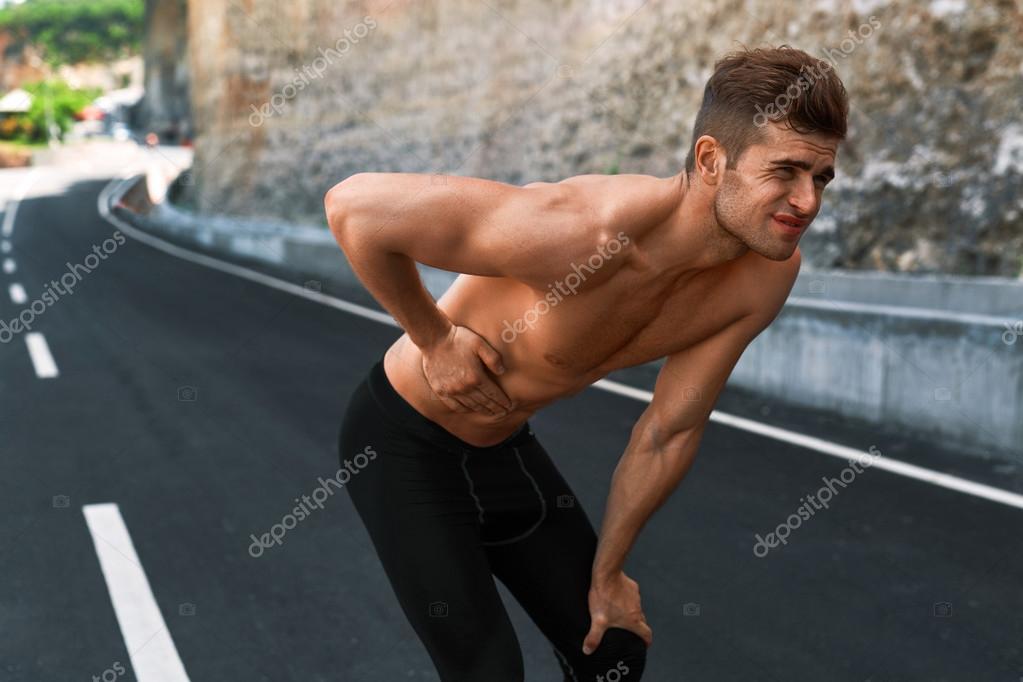 Man Suffering From Stomach Pain After Running Outdoors. Sport Injury