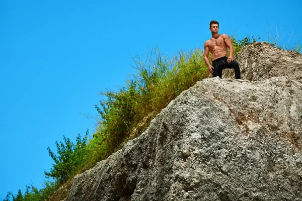 Uomo atletico escursionista muscolare sulla collina in estate. Sport all'aperto — Foto Stock