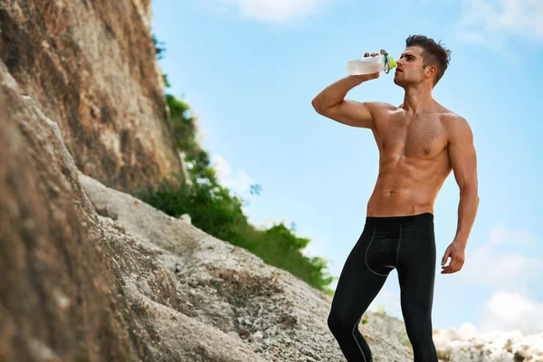 Heißdurstiger Mann trinkt nach dem Laufen im Freien Wasser. Sport — Stockfoto