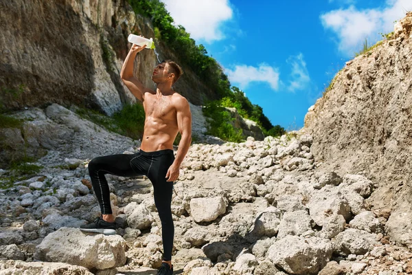 Hombre caliente vertiendo agua refrescante sobre la cara después de hacer ejercicio al aire libre — Foto de Stock