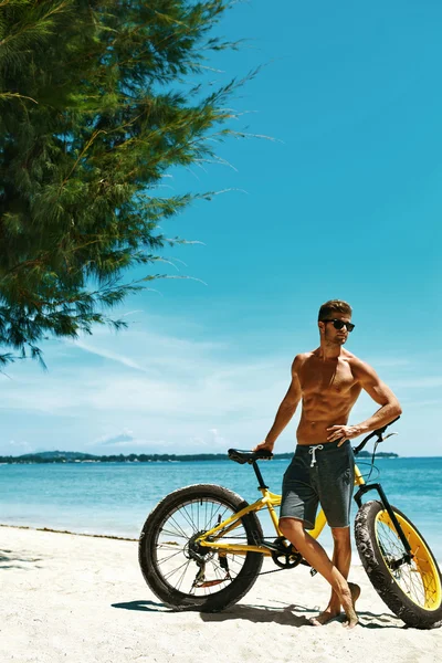 Bărbat cu nisip biciclete pe plajă bucurându-se de vacanță de vară — Fotografie, imagine de stoc