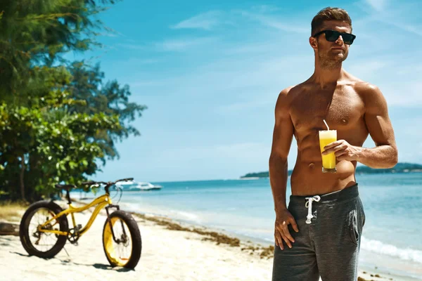 Чоловік п'є сік Смугастий коктейль на літньому пляжі. Відпустка — стокове фото