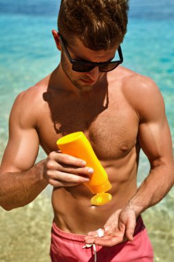 Summer Skincare. Man Applying Sunscreen Protection Body Lotion 