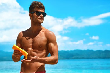 Summer Skincare. Man Applying Sunscreen Protection Body Lotion 