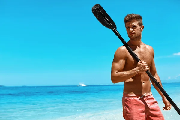 Sports nautiques d'été. Homme avec canoë kayak pagaie sur la plage — Photo