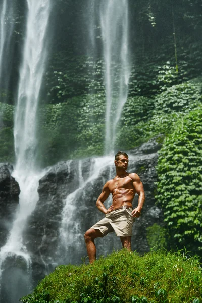 Wasser. gesunder Mann mit sexy Körper in der Nähe des Wasserfalls. Gesundheit — Stockfoto