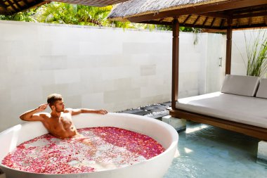 Adam rahatlatıcı Spa Bath gün açık havada çiçeklerle