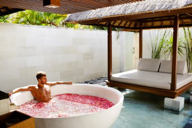 Adam rahatlatıcı Spa Bath gün açık havada çiçeklerle