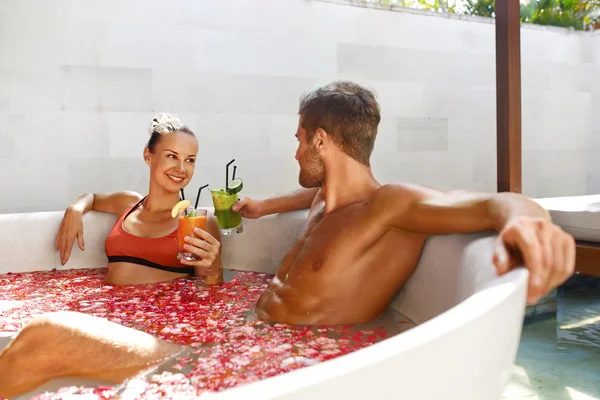 Spa koppla av. Par i kärlek i blomma bad druckit drinkar — Stockfoto