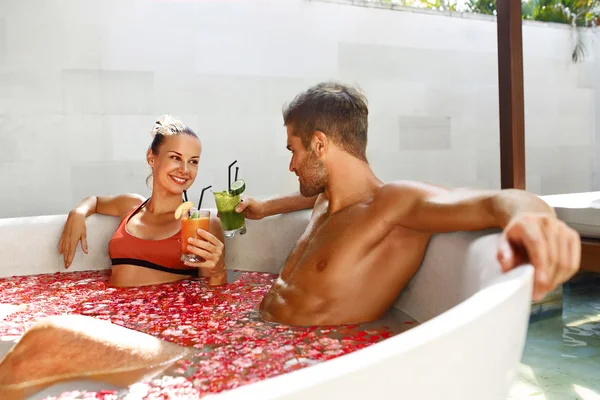 Spa koppla av. Par i kärlek i blomma bad druckit drinkar — Stockfoto