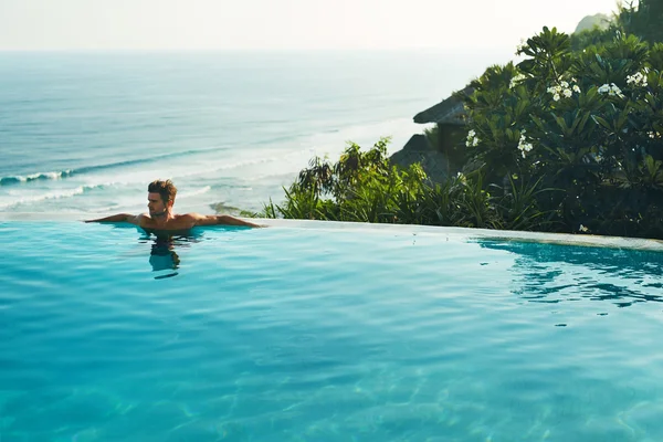 Resort di lusso. Un uomo che si rilassa nella piscina. Vacanze estive di viaggio — Foto Stock