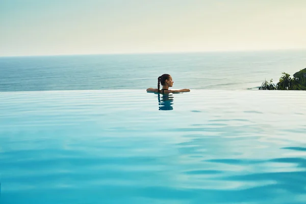 Resort de lujo. Mujer relajándose en la piscina. Vacaciones de verano — Foto de Stock