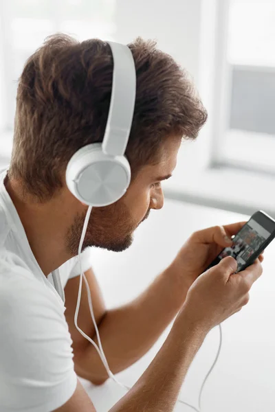 ฟังเพลง Man In หูฟัง ใช้โทรศัพท์มือถือในร่ม — ภาพถ่ายสต็อก