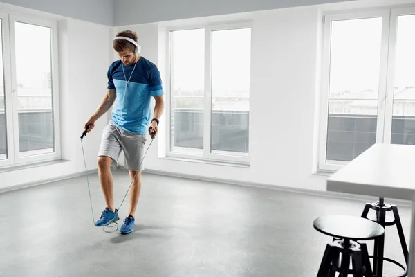 Entrenamiento Deportivo Fitness. Hombre saludable saltar la cuerda de salto en interiores . — Foto de Stock