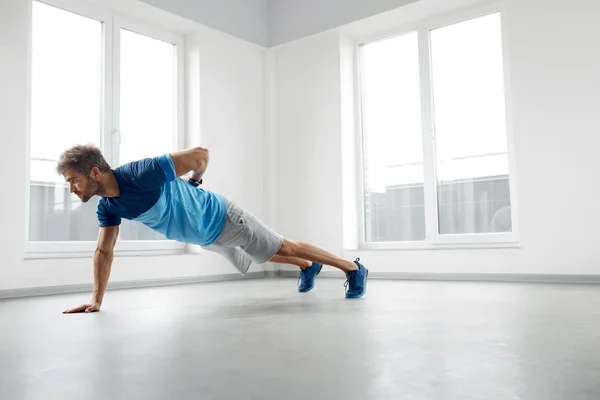 Man Workout Exercises. Fitness Male Model Doing Push Ups Indoors — Stock Photo, Image