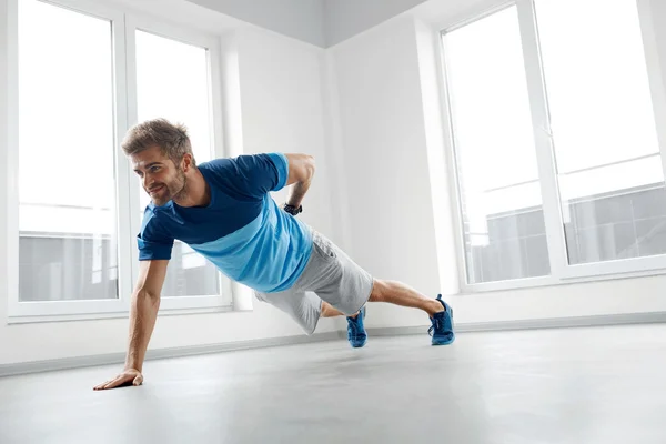 Man Workout Exercises. Fitness Male Model Doing Push Ups Indoors — Stock Photo, Image