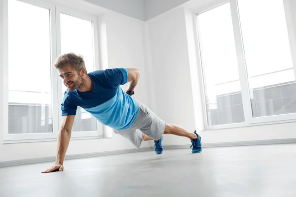 Ejercicios de entrenamiento de hombre. Fitness Modelo Masculino Hacer push Ups en interiores —  Fotos de Stock