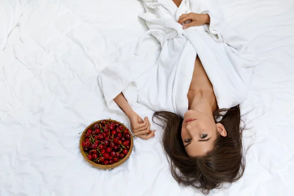 Υγιεινή διατροφή φαγητό για την υγεία των γυναικών. Κορίτσι τρώει φρούτα στο κρεβάτι — Φωτογραφία Αρχείου