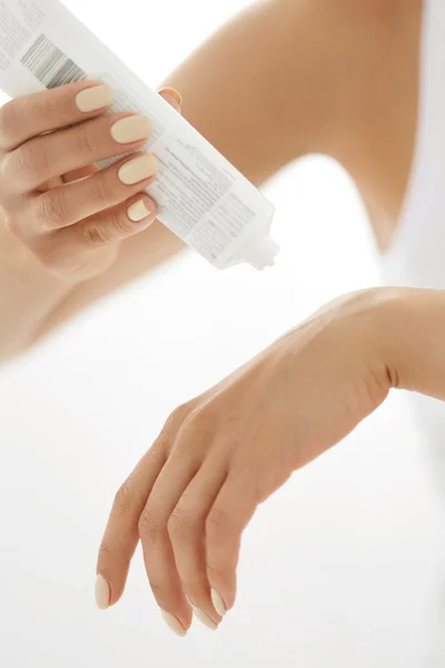 Cuidados com a pele da mão. Closeup de mãos femininas segurando tubo de creme — Fotografia de Stock