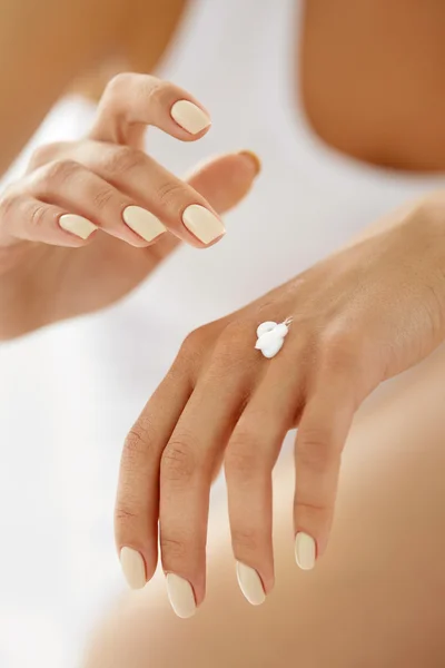 Crema de manos. Primer plano de las manos de la mujer aplicando loción en la piel — Foto de Stock