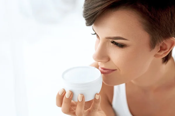 Huidverzorging. Mooie gelukkige vrouw Holding face Cream lotion — Stockfoto
