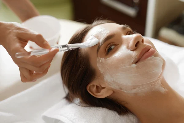 Hautpflege. schöne Frau bekommt Kosmetikmaske im Wellness-Salon — Stockfoto