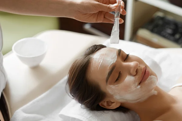 Trattamento di bellezza facciale. Bella donna ottenere maschera cosmetica — Foto Stock