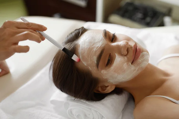 Gesichtsbehandlung. schöne Frau bekommt kosmetische Maske — Stockfoto