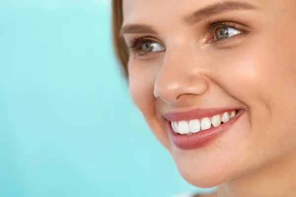 Kaunis nainen, jolla on kauniit kasvot, terveet valkoiset hampaat hymyilevä — kuvapankkivalokuva