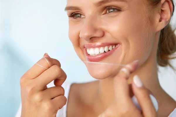 Tandheelkundige hygiëne. Mooie vrouw flossen gezonde witte tanden — Stockfoto
