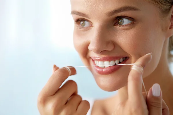 Cuidado com os dentes. Mulher sorridente bonita Flossing dentes brancos saudáveis — Fotografia de Stock